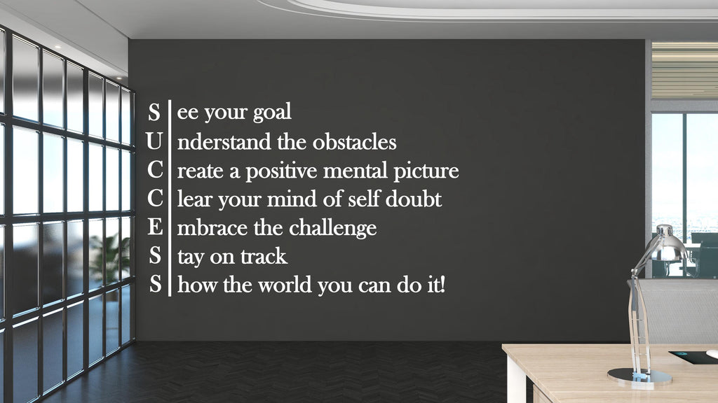 May include: A motivational wall art piece with the word "SUCCESS" spelled vertically, each letter followed by an inspirational phrase. The phrases are in white against a dark gray wall. The room has a modern office setting with a desk and a window.