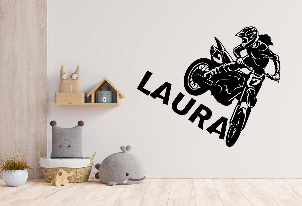 May include: Black and white wall decal of a person riding a dirt bike with the name "LAURA" written below.